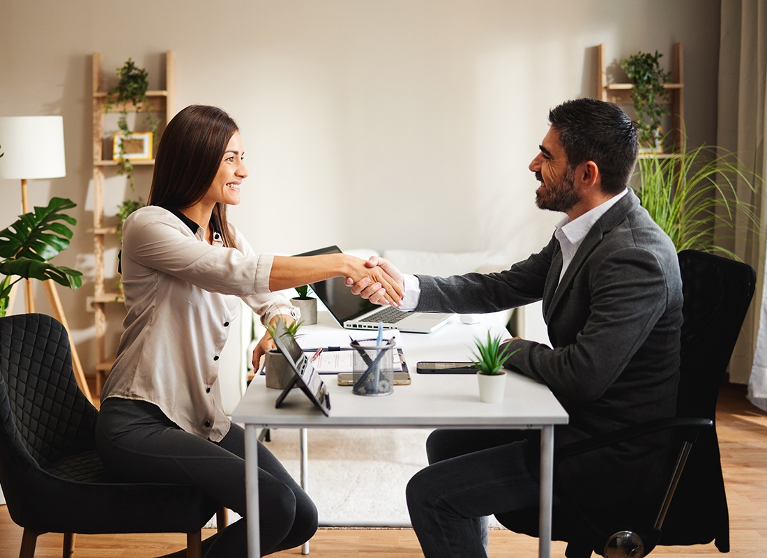 We Are Independent - View of a Smiling Middle Aged Agent Shaking Hands with a Female Client During a Meeting in the Office